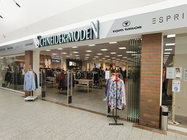 Storefront eines Modegeschäfts mit den Marken Schneider-Moden und Tom Tailor.
