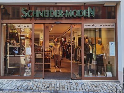 Geschäftsvorstellung von Schneider-Moden mit Kleidung im Schaufenster.