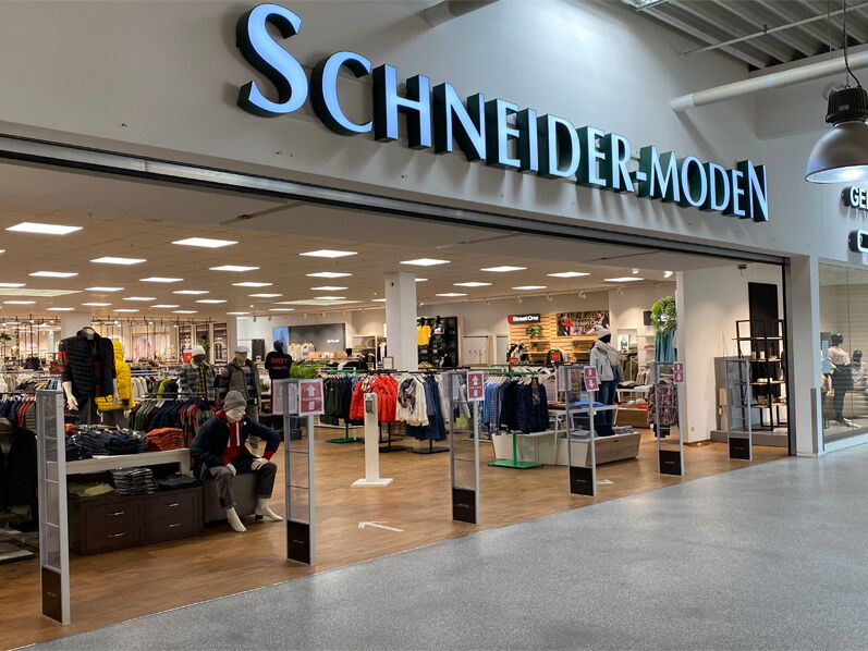 Innenansicht eines Modegeschäfts mit dem Schriftzug Schneider-Moden.